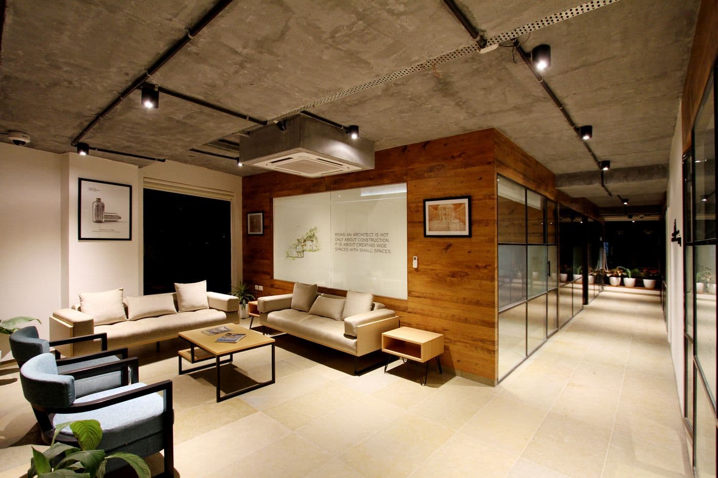 Area lounge kerja santai dengan sofa dan pencahayaan hangat